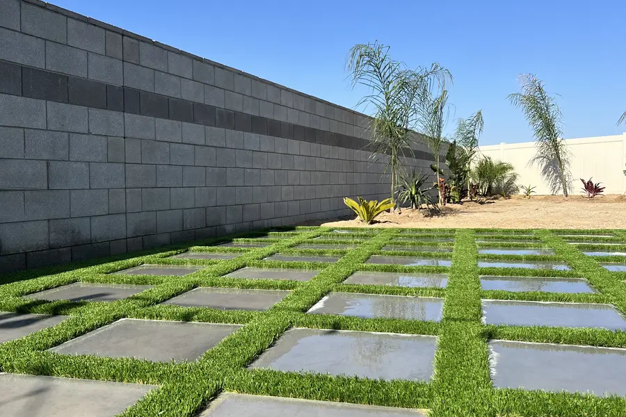 Artificial turf fitted cleanly between a geometric paver grid