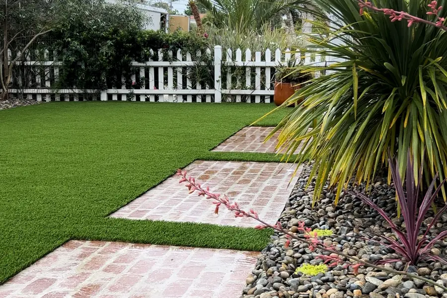 Fresh, clean artificial lawn beside a white picket fence