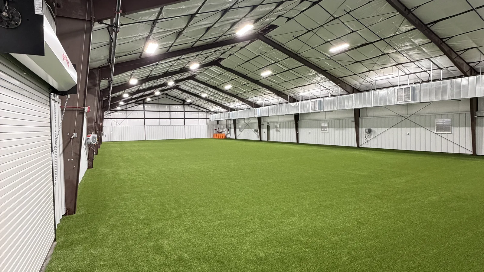 Indoor commercial turf training field under warehouse lighting