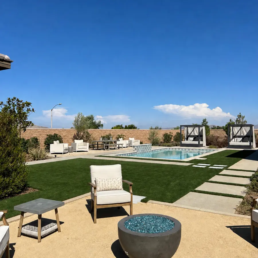Finished backyard with pool, lounge seating, and a fire bowl beside artificial turf