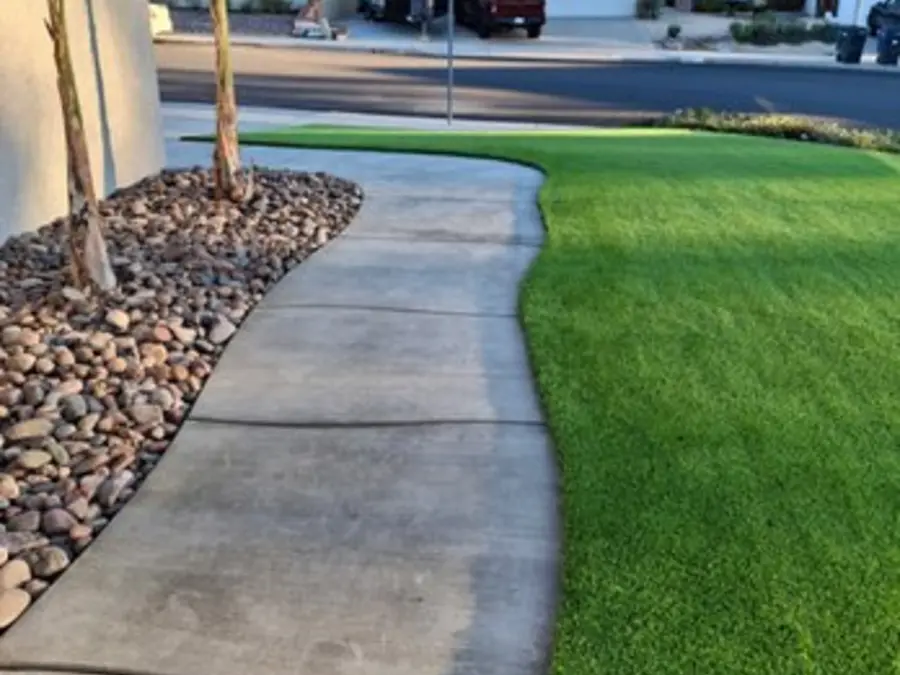 Curved concrete walkway through fresh artificial turf