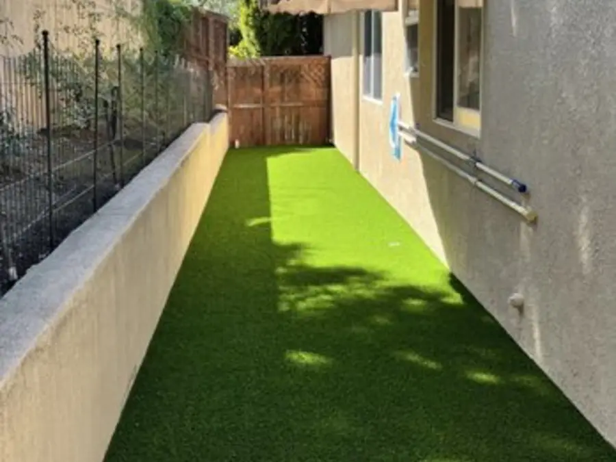 Side-yard dog run with new turf